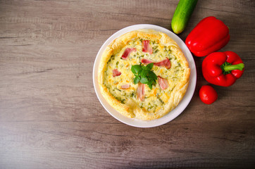 Homemade Spinach and Bacon Egg Quiche in a pie crust on wood board. French cuisine flat design