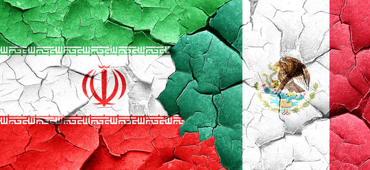 iran flag with Mexico flag on a grunge cracked wall