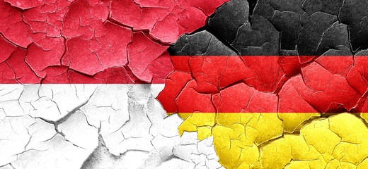 Indonesia flag with Germany flag on a grunge cracked wall