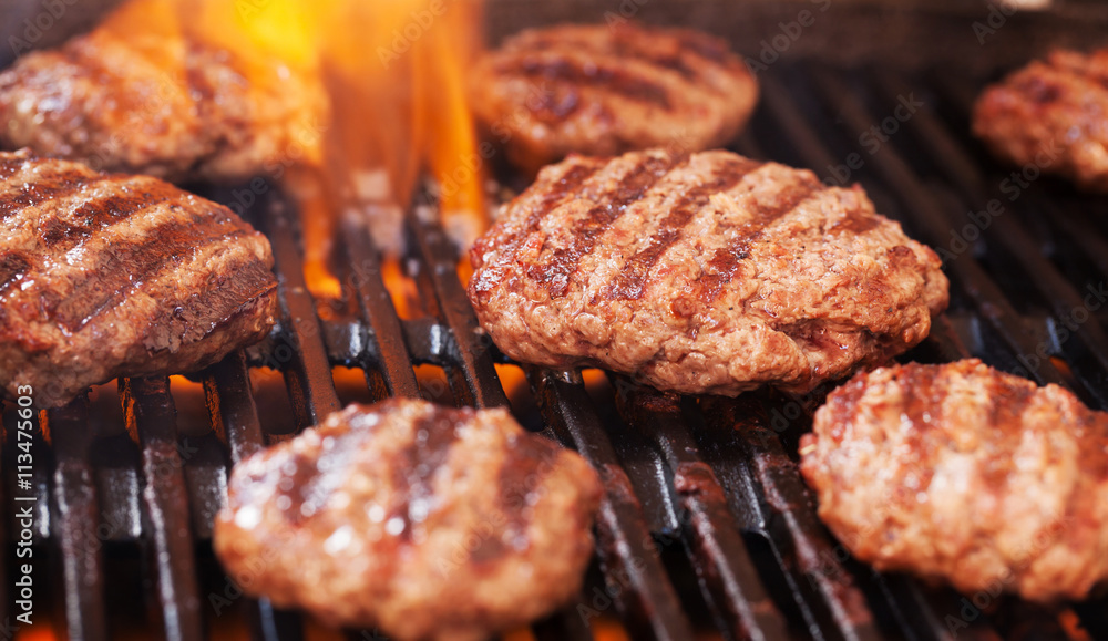 Wall mural burgers cooking on grill