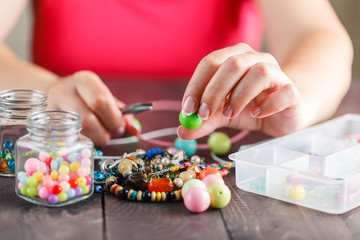 Woman designing colorful necklace with plactic beads