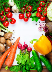 Beautiful background healthy organic eating. Studio photography the frame of different vegetables and mushrooms with a white sheet of paper on the old brown boards with free space