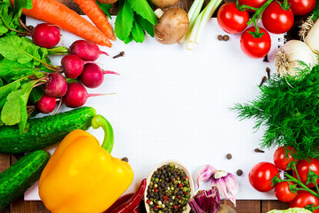 Beautiful background healthy organic eating. Studio photography the frame of different vegetables and mushrooms with a white sheet of paper on the old brown boards with free space