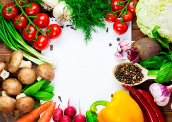 Beautiful background healthy organic eating. Studio photography the frame of different vegetables and mushrooms with a white sheet of paper on the old brown boards with free space