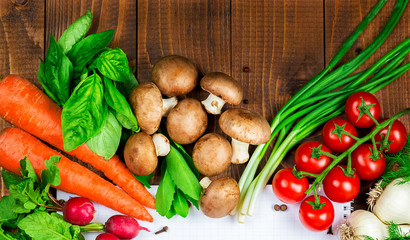 Beautiful background healthy organic eating. Studio photography the frame of different vegetables and mushrooms with a white sheet of paper on the old brown boards with free space