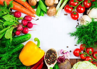 Beautiful background healthy organic eating. Studio photography the frame of different vegetables and mushrooms with a white sheet of paper on the old brown boards with free space