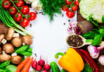 Beautiful background healthy organic eating. Studio photography the frame of different vegetables and mushrooms with a white sheet of paper on the old brown boards with free space