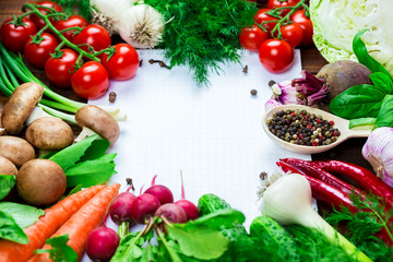 Beautiful background healthy organic eating. Studio photography the frame of different vegetables and mushrooms with a white sheet of paper on the old brown boards with free space
