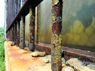 Vintage old rusty peeling paint steel security window bar