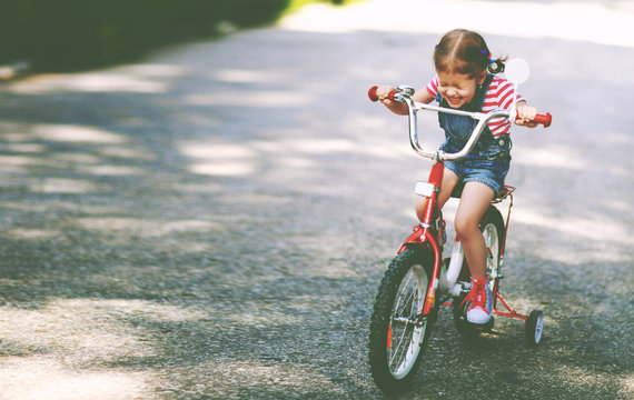 happy child girl cyclist riding a bike