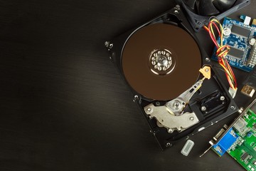 Open hard drive on a black wooden background. Production of computers. Electronics store. Backing...