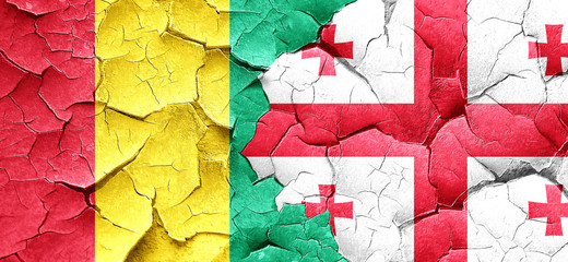 Guinea flag with Georgia flag on a grunge cracked wall