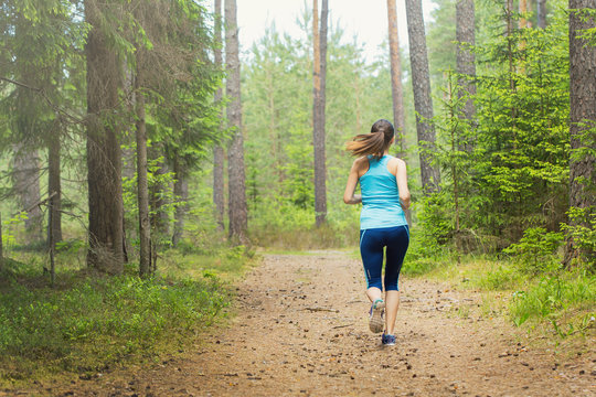 Woman fitness jogging workout in nature, wellness concept.