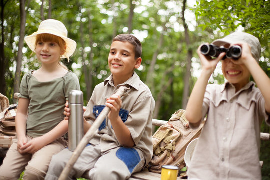 young boy  explores the nature with binoculars