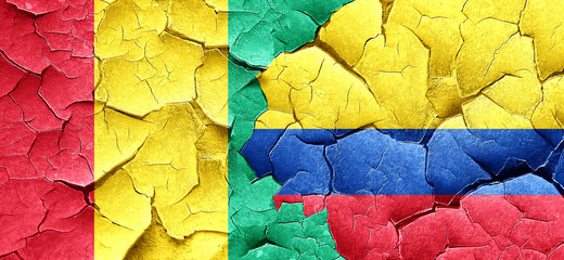 Guinea flag with Colombia flag on a grunge cracked wall
