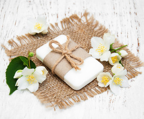 Obraz na płótnie Canvas jasmin flowers and soap on a old wooden table