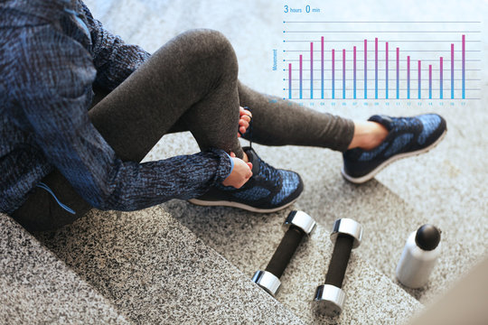 Running schedule concept. Sports woman in sneakers sitting on stairs