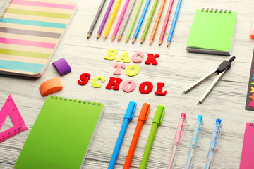 School set with back to school inscription, notebooks on light wooden background