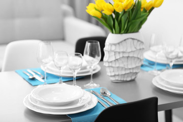 Table served with dishes and a bouquet of tulips