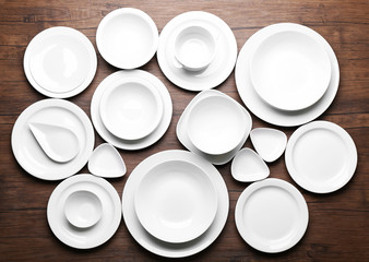Set of white dishes on wooden background