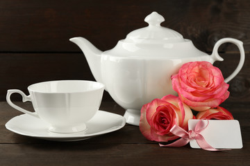 Happy Mother's day concept. White tableware, roses and card on wooden background