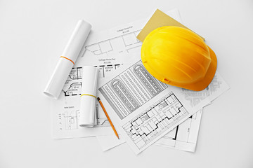Yellow helmet on the table with blueprints