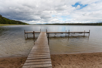 Naklejka premium Cloudy sky over lake and bridge