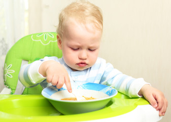 Cute little child eating blended carrot