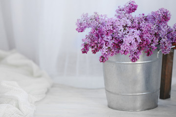 Bouquet of lilac flowers on white wooden floor