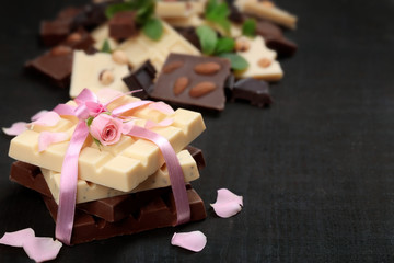 Chocolate tied with pink ribbon on black background