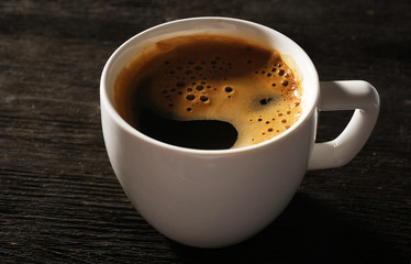 Cup of fresh coffee on wooden background