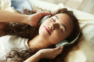 African American listening to music in headphones in bed