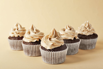 Tasty cupcakes on color background
