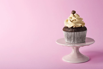 Tasty cupcake on color background
