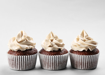 Tasty cupcakes on light background