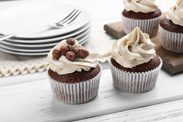 Tasty cupcakes on wooden table