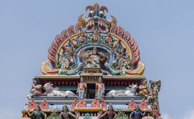 Chettinad, India - October 17, 2013:Detail of the Shiva temple gopuram at Kottaiyur shows Devi Saraswati playing the Veena with dancers and singers. Plenty of colorful statues.