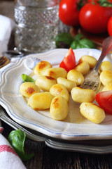  Fried potato gnocchi with cheese and tomatoes
