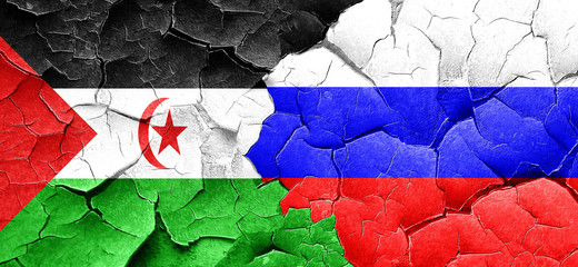 Western sahara flag with Russia flag on a grunge cracked wall