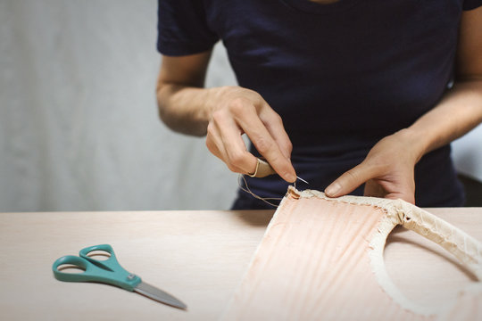 Midsection of fashion designer stitching fabric at table in workshop