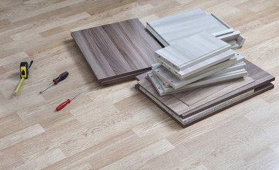 Chipboard for assembly furniture lying on floor next to screwdri