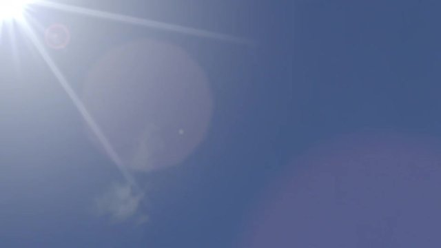 Boeing 787 passenger airplane flying across the sky against the sun, 4K video