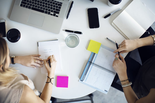 Overhead view of businesswomen planning at table in creative office