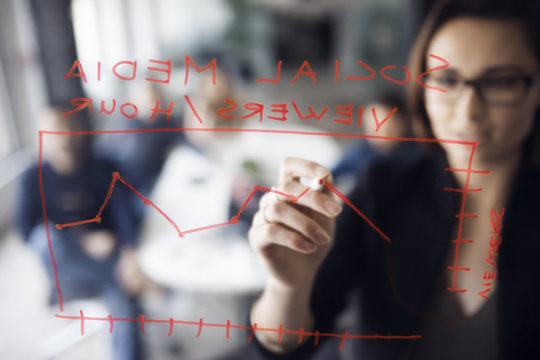 Businesswoman making chart in creative office