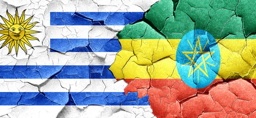 Uruguay flag with Ethiopia flag on a grunge cracked wall
