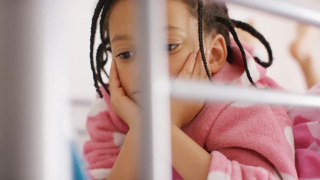 4K Young girl in her bed watches something on a digital tablet, in slow motion