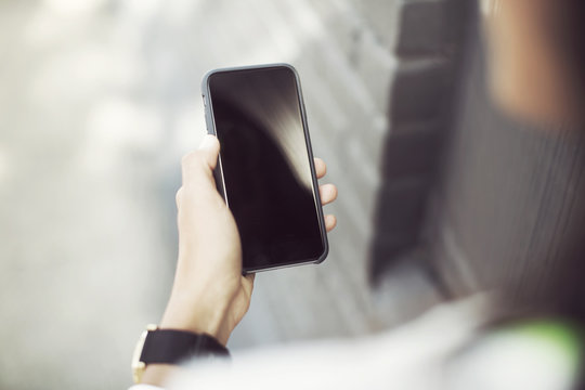 Cropped image of woman holding smartphone