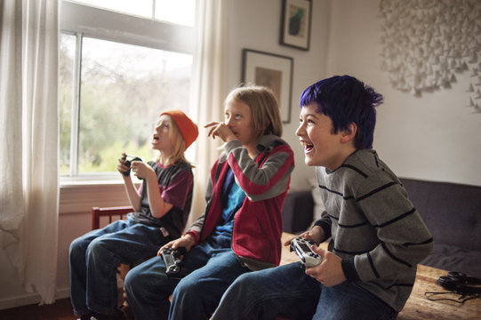 Smiling boys playing video games at home