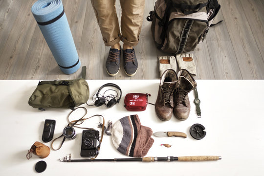 Low section of man standing with objects arranged on table at home