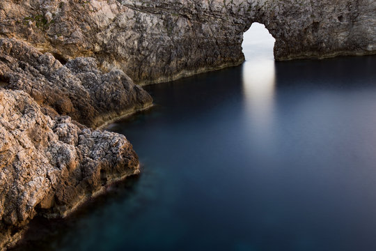 High angle view of natural arch over calm sea